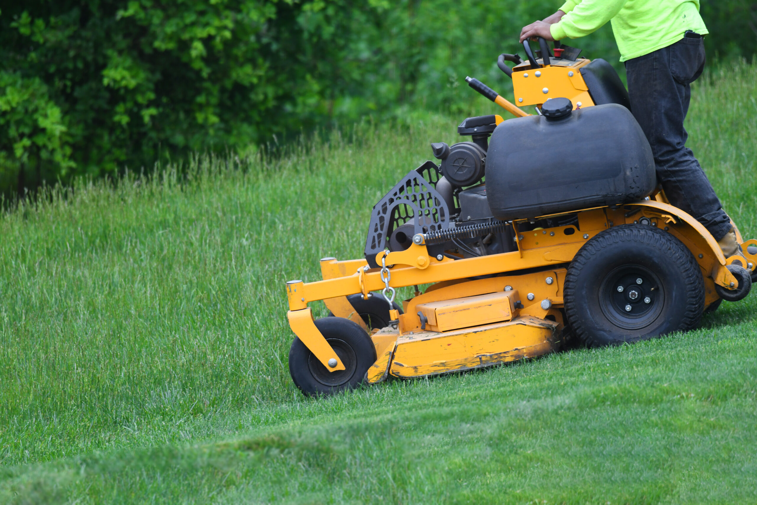  manual worker mowing the lawn